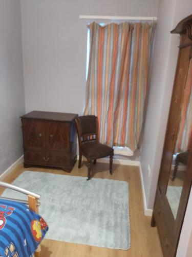 a bedroom with a chair and a dresser and a window at Hardwood Hall or Kiltubber House in Kinnegad
