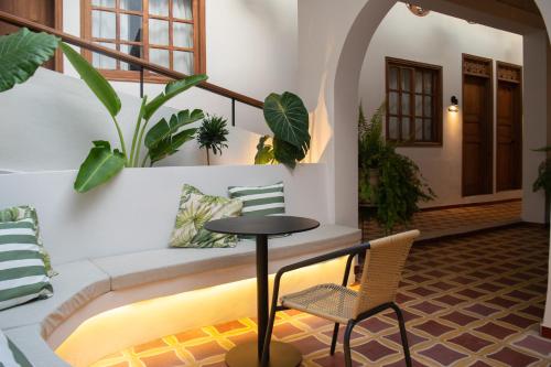 a patio with a table and chairs and plants at Casa Zoé Hotel Boutique in Villeta