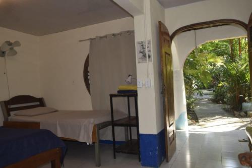 a room with a bed and an open doorway at Cabinas carol in Pavones