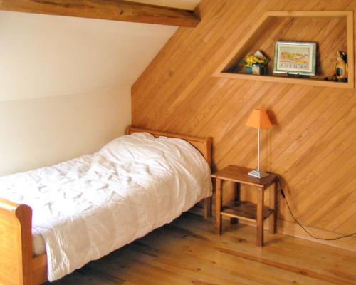 a bedroom with a bed and a table with a lamp at Villa charmante à Issac avec piscine privée in Issac