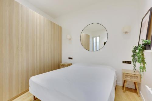 une chambre avec un lit blanc et un miroir dans l'établissement Beautiful 2 BDR Duplex in Paris, à Paris