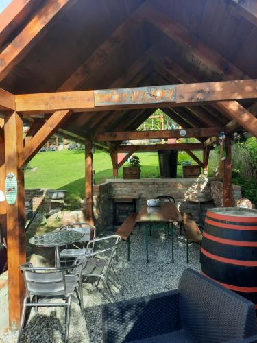 a patio with a table and chairs and a fireplace at Domceky Holiday in Liptovský Trnovec