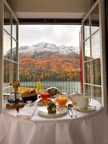 a table with food and a view of a mountain at Hotel GRACE LA MARGNA ST MORITZ in St. Moritz