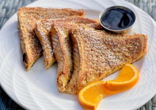 a white plate with two pieces of toast and an orange slice at The Ridges Resort on Lake Chatuge in Young Harris