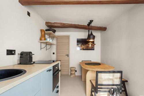 - une cuisine avec une table en bois et un comptoir dans l'établissement Maison Gaï Soleil, à Grimaud