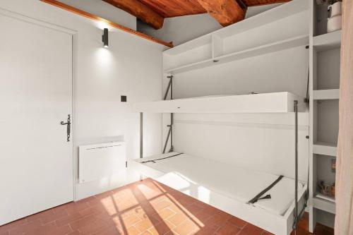 Cette chambre dispose d'étagères blanches et d'un plafond en bois. dans l'établissement Maison Gaï Soleil, à Grimaud