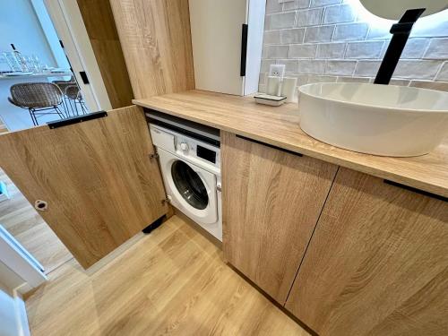 ein Badezimmer mit Waschbecken und Waschmaschine in der Unterkunft Appart Matisse face mer parking in Sainte-Maxime