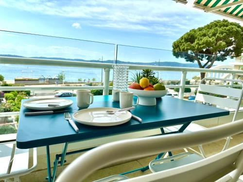 une table bleue avec un bol de fruits sur un balcon dans l'établissement Appart Matisse face mer parking, à Sainte-Maxime
