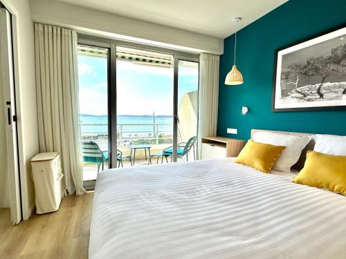 ein Schlafzimmer mit einem großen Bett mit einer blauen Wand in der Unterkunft Appart Matisse face mer parking in Sainte-Maxime