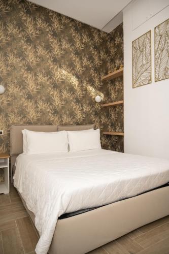 a bedroom with a large white bed with a wall at Four Pompei in Pompei