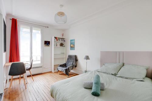 une chambre avec un lit, un bureau et une chaise dans l'établissement Studio Lumineux au pied du RER A - Avec ascenseur, à Vincennes