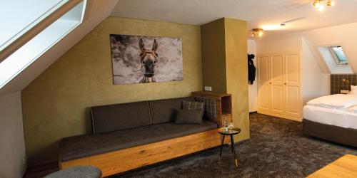 a room with a couch with a horse picture on the wall at Hotel Sonne Garni in Hinterzarten