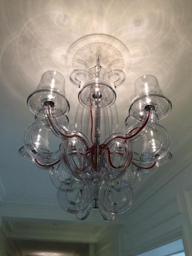 a glass chandelier hanging from a ceiling at Relais12bis Bed & Breakfast By Eiffel Tower in Paris