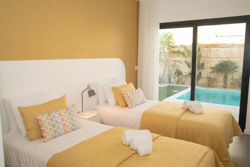 Dos camas en una habitación con piscina. en Casa do Cruzeiro - BY SCH, en Foz do Arelho