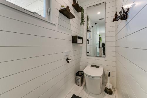 a white bathroom with a toilet and a mirror at 1 Mi to Bonita Beach Park Chic Canal-Front Home! in Bonita Springs
