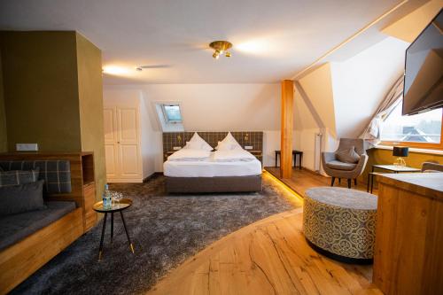 a hotel room with a bed and a couch at Hotel Sonne Garni in Hinterzarten
