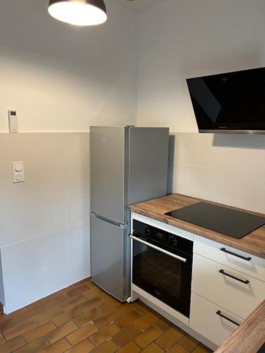 a kitchen with a refrigerator and a stove at Maison chaleureuse et conviviale in La Caillaudière