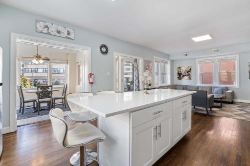 a kitchen and living room with a white counter and chairs at Luxe Beach Estate - 4 Bedrooms and 3 Bathrooms in Atlantic City