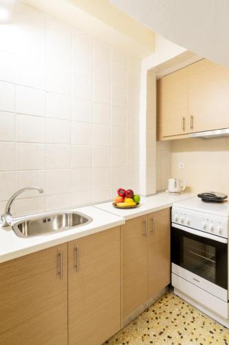 a kitchen with a sink and a bowl of fruit on a plate at Aloe Apartments in Sitia