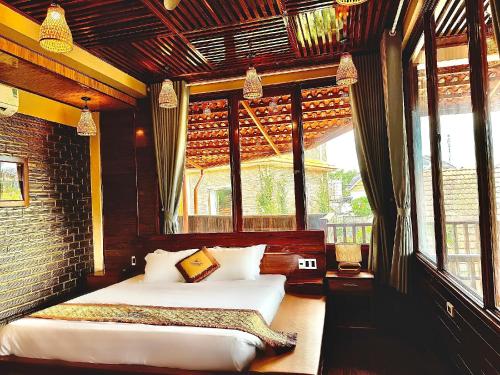 a bedroom with a bed and a large window at Golden Topaz Phu Quoc Resort in Phu Quoc