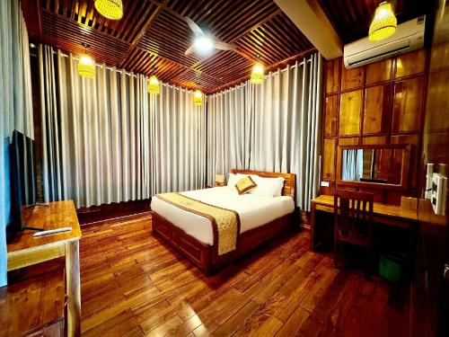a bedroom with a bed and a desk in it at Golden Topaz Phu Quoc Resort in Phu Quoc