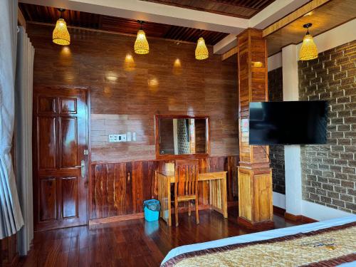 a living room with a television and a table with a table at Golden Topaz Phu Quoc Resort in Phu Quoc