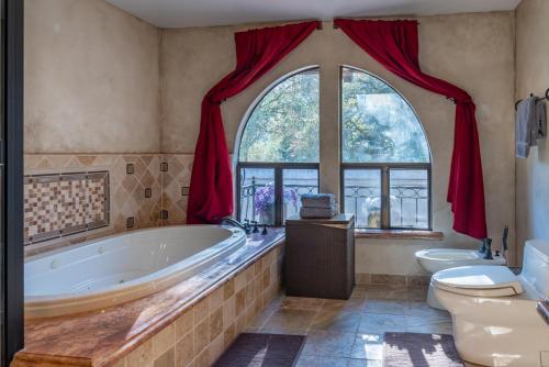 a bathroom with a tub and a toilet and a window at San Antonio Estate in Atascadero