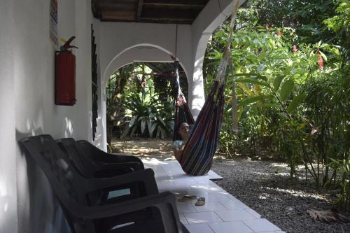a girl sitting in a hammock on a porch at Cabinas carol in Pavones