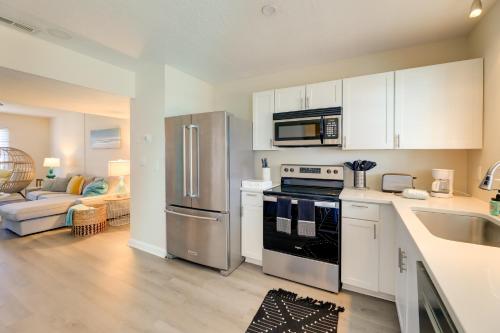 a kitchen with a stainless steel refrigerator and white cabinets at half Mi to Atlantic Beach Townhome with Balcony! in Atlantic Beach