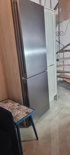 a refrigerator with a table next to a door at Acharavi Serenity Cozy Home in Acharavi