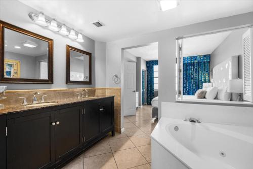 een badkamer met een bad en een wastafel en een ligbad bij Marvelous Oceanfront 12th Floor 3BR Retreat at The WyndhamOcean Walk Resort in Daytona Beach