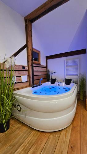 a white bath tub in a room with a wooden floor at Hiša stare mame in Kamnik