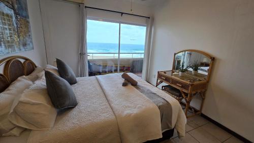 a bedroom with a bed with a view of the ocean at 407 L'Escalier Cabanas -Beachfront Paradise in Amanzimtoti