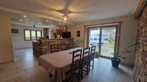 une cuisine et une salle à manger avec une table et des chaises dans l'établissement La ferme du Moulin Taquère, à Le Val-dʼAjol
