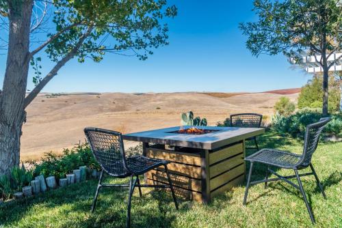 a table and chairs with a fire pit in the grass at Sunset at Nirvana in San Miguel