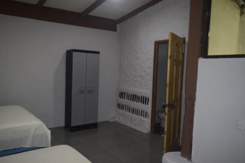 a room with a bed and a mirror and a door at Cabinas carol in Pavones