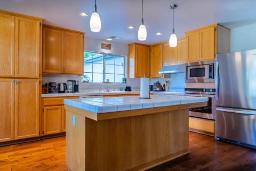 a large kitchen with wooden cabinets and a stainless steel refrigerator at Sea Rock Ranch in Templeton