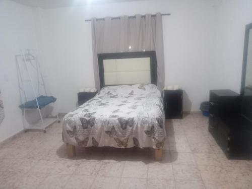 1 dormitorio con cama con edredón en Departamento para 5 o 7, en Uruapan del Progreso