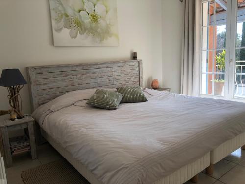 un lit avec deux oreillers dessus dans une chambre dans l'établissement Villa avec piscine dans les oliviers, à Belgentier