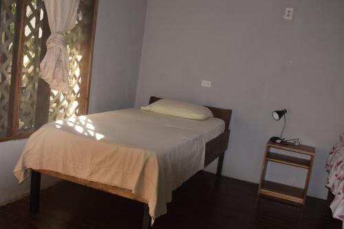 a small bed in a room with a window at Cabinas carol in Pavones