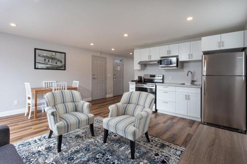 a kitchen with two chairs and a stainless steel refrigerator at Picton Harbour Inn in Picton