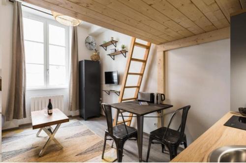 une pièce avec une table, des chaises et une fenêtre dans l'établissement Roussy - Croix Rousse, à Lyon