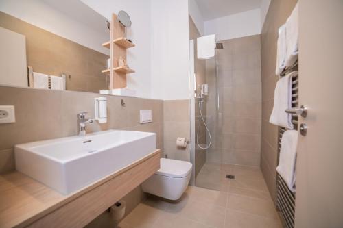 a bathroom with a white sink and a toilet at Summit of Saxony Resort Oberwiesenthal in Kurort Oberwiesenthal