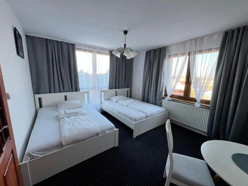 a hotel room with two beds and a table at Noclegi AirportPark in Pyrzowice