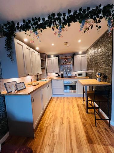 a kitchen with white cabinets and a wooden floor at Latitude Chinatown Central Apartment in Birmingham