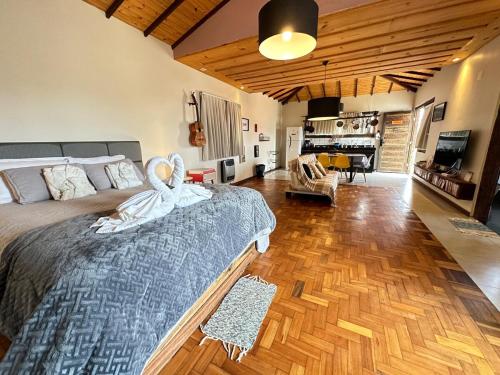 a bedroom with a large bed and a living room at Refúgio de Lavras in Ouro Preto