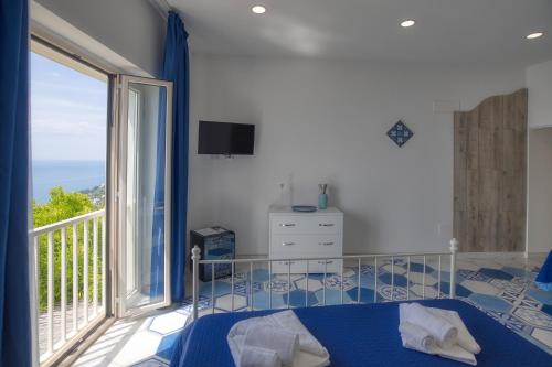 a bedroom with a bed and a large window at Tenuta La Picola in Furore