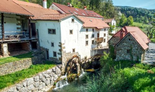 a group of buildings next to a river at Hiška Kovačija in Vremski Britof