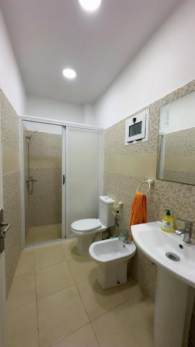Un baño con inodoro, lavabo y ducha. en Spacious apartment, en Settat