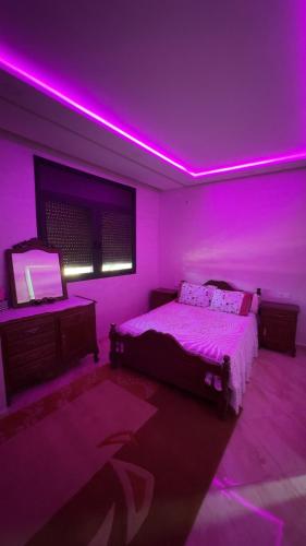 1 dormitorio con cama e iluminación púrpura en Spacious apartment, en Settat
